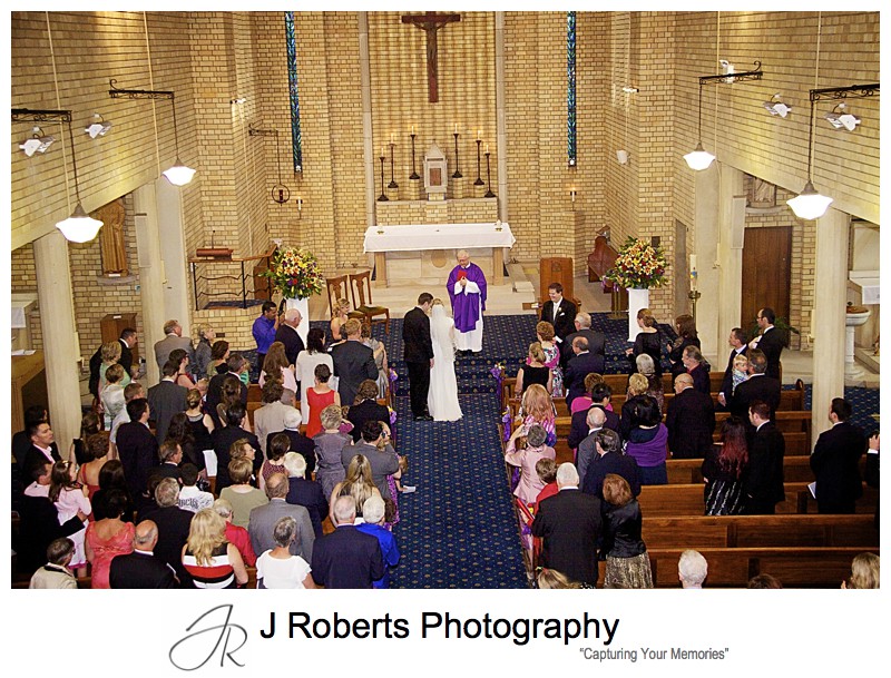 Groom whispering to bride when he sees her at the church - wedding photography sydney